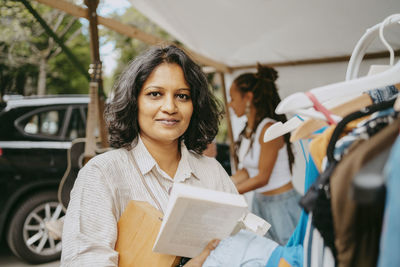 Portrait of female customer buying books at flea market