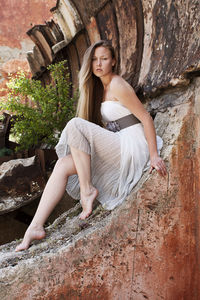 Portrait of woman sitting on rock