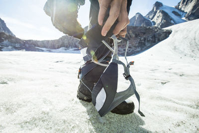 Detailed low angle view of climber stepping into climbing harness.