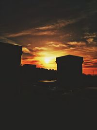 Silhouette buildings against sky during sunset