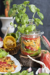 Orange salad of paprika, tomatoes, carrots and basil, harvesting in a jar