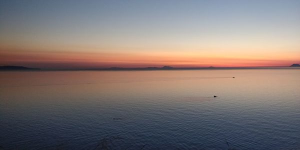 Scenic view of sea against clear sky during sunset