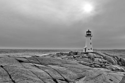 Lighthouse by sea against sky