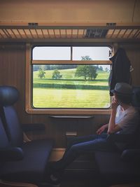 Rear view of woman sitting in train