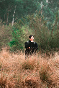 Portrait of young man standing on field