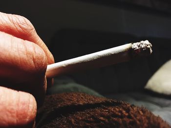 Close-up of hand holding cigarette