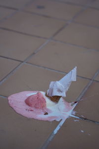 High angle view of pink paper on tiled floor