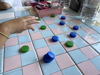 Cropped hand of woman playing with toy blocks on table