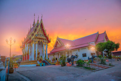 Illuminated traditional building against sky at sunset