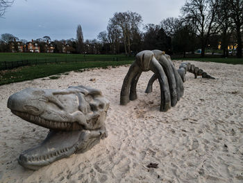 Horse sculpture on field against sky