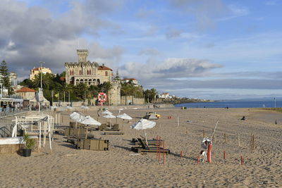 People on beach by sea against sky