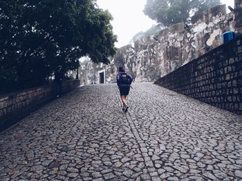 Rear view of woman walking on footpath at fortaleza do monte