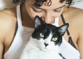 Close-up of young woman with cat at home