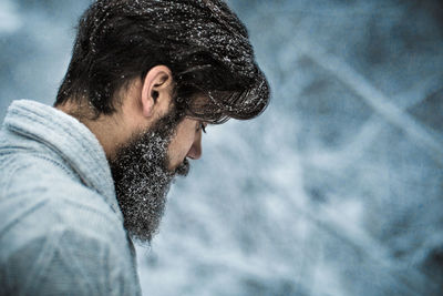 Side view of bearded man during snowfall