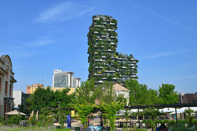 People in front of building against blue sky