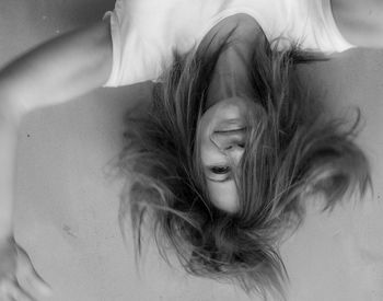 Portrait of young woman lying down on bed