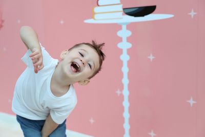 Portrait of smiling boy standing against wall