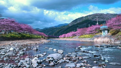 Scenic view of river by mountains against sky