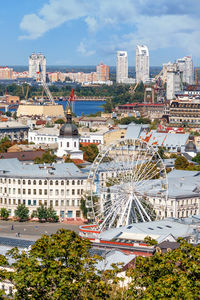 A view of the old podil, summer kyiv, the ferris wheel, dense residential buildings .