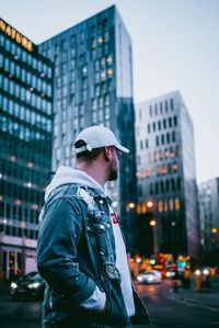 Side view of young man standing on city street