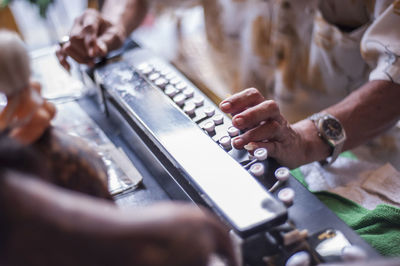 Midsection of man playing old musical instrument