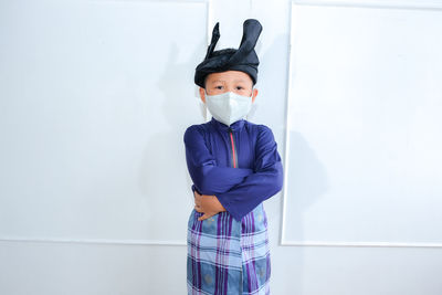 Kids portrait with baju melayu eid fitr celecration. boy using face mask cause of covid-19outbreak.