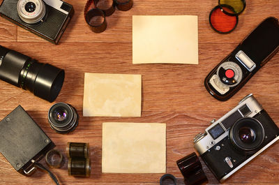 Directly above shot of cameras and photographs on table