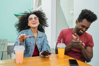 Happy friends sitting on table