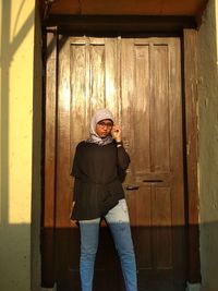 Woman wearing hijab standing by door