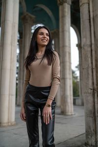 Portrait of young woman standing in city