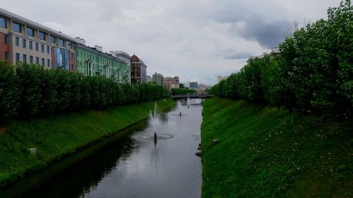 Scenic view of canal by building against sky