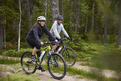 View of people cycling through forest