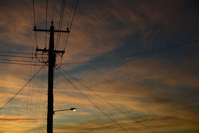 Low angle view of silhouette electric pole against sky during sunset