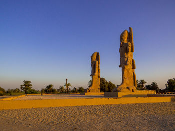 Built structure on landscape against clear blue sky