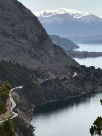 Scenic view of river by mountains against sky
