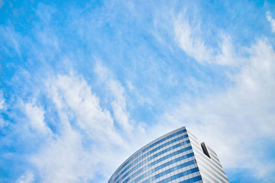 Low angle view of modern building against blue sky