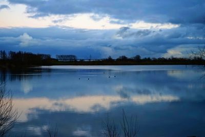 Scenic view of lake against sky at sunset