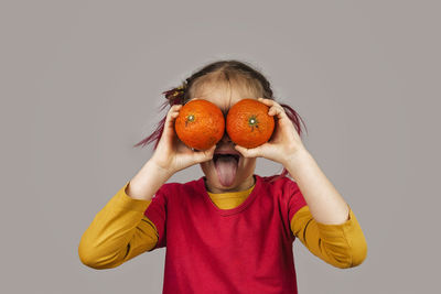 Midsection of man holding orange against white background