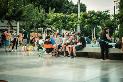 People enjoying in swimming pool against trees