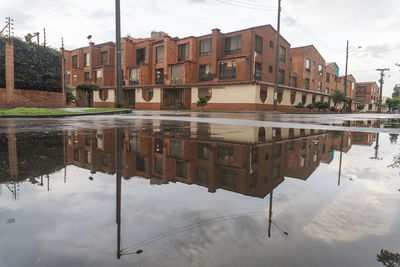 Reflection of buildings in puddle on lake