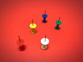 High angle view of multi colored thumbtacks on table