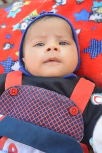 Close-up high angle portrait of cute baby boy lying on bed