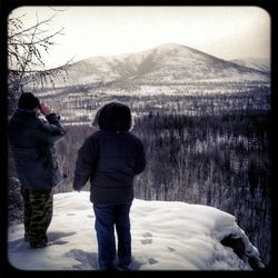 Rear view of woman hiking on snow covered landscape