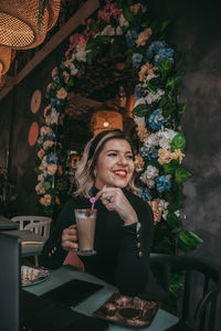 Portrait of smiling woman sitting on table