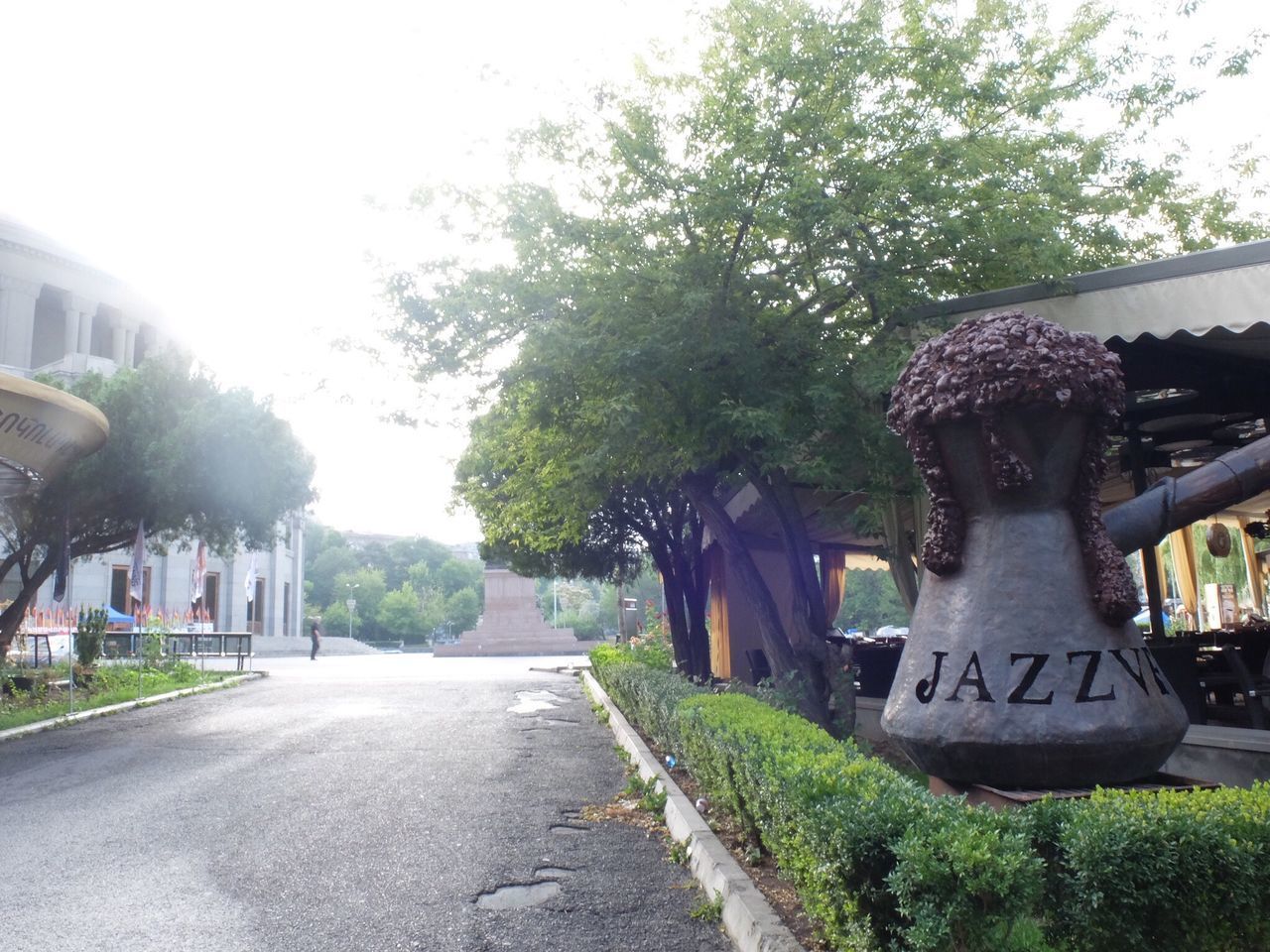 ROAD AMIDST TREES IN CITY AGAINST SKY