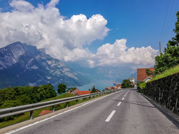 Road by mountains against sky