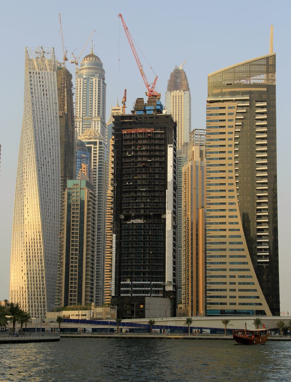 architecture, building exterior, built structure, city, skyscraper, tall - high, tower, waterfront, water, modern, capital cities, office building, development, travel destinations, famous place, crane - construction machinery, international landmark, river, urban skyline, travel