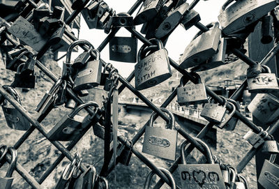 Close-up of padlocks on chainlink fence at bridge