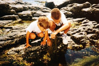 Mother and son standing on rock