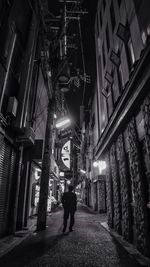 Full length of woman walking in illuminated city at night